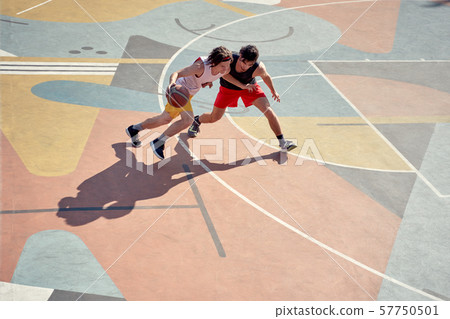 Top view photo of two young athletes men playing basketball on playground in morning. 57750501