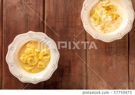 Tortellini with broth and cream sauce, Italian food, shot from the top on a dark rustic wooden Tortellini with broth and cream sauce, Italian food, shot from the top on a dark rustic wooden 57750973