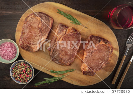 Beef fillet steaks, shot from the top on a dark rustic wooden background with rosemary, salt, pepper 57750980