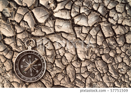 Top view of compass on the cracked dry soil 57751509