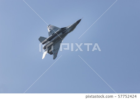 A military fighter jet with red stars on the wings flying in the sky 57752424