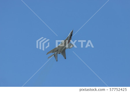 A gray military fighter jet flying in the sky upside down A gray military fighter jet flying in the sky upside down 57752425