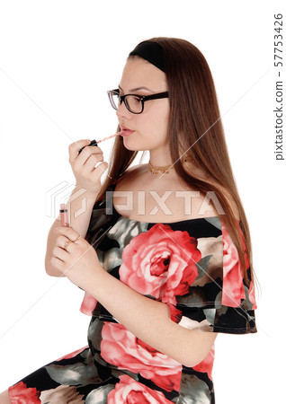 Pretty teenager girl fixing her lips in profile, 57753426