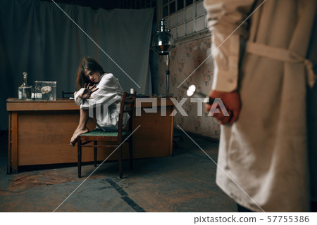 Psychiatrist with syringe and crazy female patient 57755386