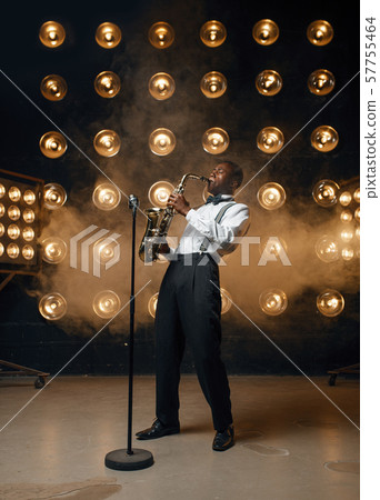 Male jazzman plays the saxophone on stage Male jazzman plays the saxophone on stage 57755464