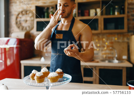 Nude man in apron cooking dessert with cream 57756133