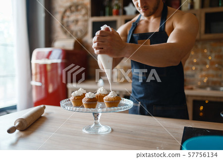 Nude man in apron cooking dessert on the kitchen Nude man in apron cooking dessert on the kitchen 57756134