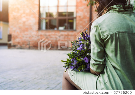 A woman sits on a bench in the courtyard in a mint-colored linen dress 57756200