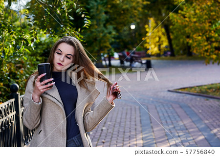 A young woman with long hair and in a woolen coat 57756840