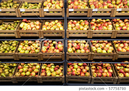 Supermarket counter with a lot of wooden boxes with fresh apples and pears 57758780