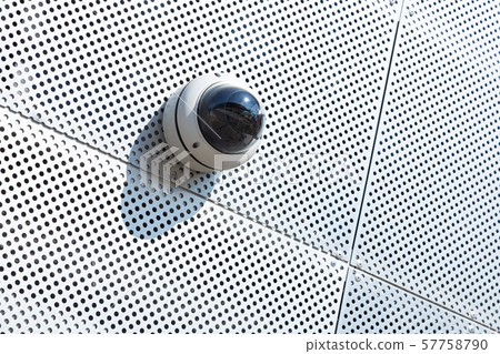 Close-up of cctv system camera on white metal surface with a lot of tiny round openings Close-up of cctv system camera on white metal surface with a lot of tiny round openings 57758790