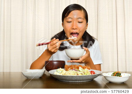 Girl eating tonkatsu 57760429