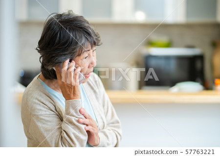 Senior woman talking on an uneasy senior smartphone, silver generation elderly woman portrait Senior woman talking on an uneasy senior smartphone, silver generation elderly woman portrait 57763221