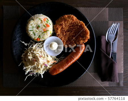 Grilled steak with fried fish, pork and sausage with sauce in the dish and bread are served with a salad streak Grilled steak with fried fish, pork and sausage with sauce in the dish and bread are served with a salad streak 57764118