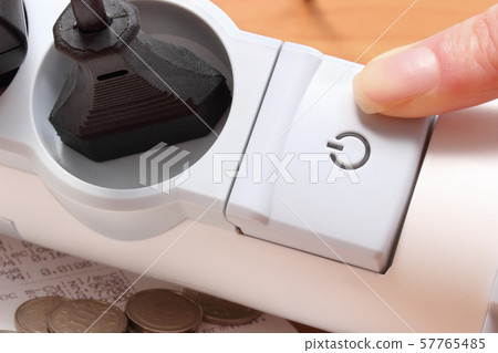 Finger of woman turns off electrical extension 57765485
