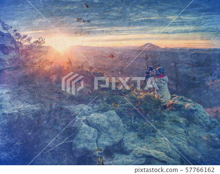 Tourist with camera shoots sunrise while standing 57766162