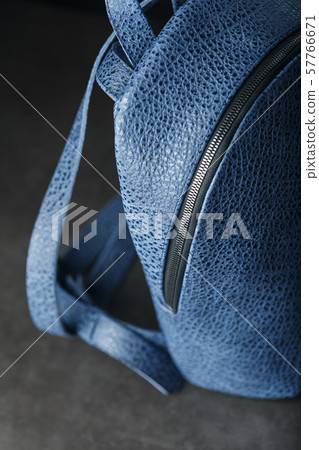 Blue backpack made of genuine leather on a dark Blue backpack made of genuine leather on a dark 57766671