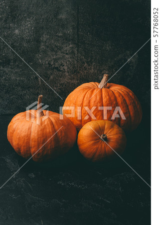 Photo of three orange pumpkins on black background, halloween celebration. 57768052