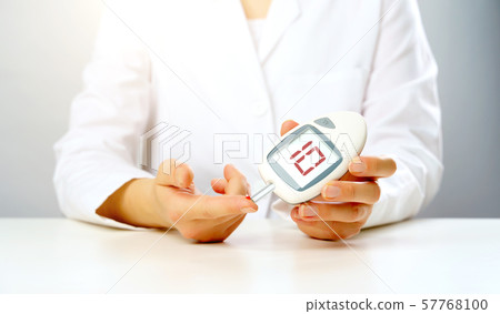 Photo of doctor's hand with glucometer with inscription ten in studio Photo of doctor's hand with glucometer with inscription ten in studio 57768100
