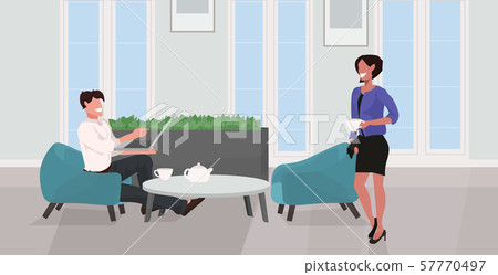 man woman drinking tea relaxing at home couple having fun using laptop and discussing together 57770497