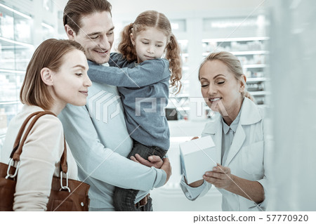 A female pharmacist showing the customers the medicines 57770920