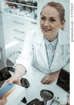 A drugstore female worker receiving the pack of pills A drugstore female worker receiving the pack of pills 57770929