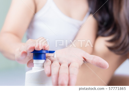 A beautiful Asian woman sitting on a bed pressing 57771865
