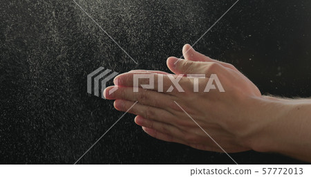 closeup man clapping hands with fine powder 57772013