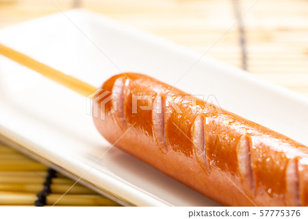 A frank with a skewer (a frankfurter sausage on a skewer). 57775376