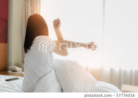 Woman stretching in bed after waking up, back 57776038