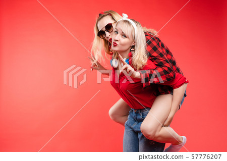 Sisters having fun giving piggyback.Stock studio 57776207