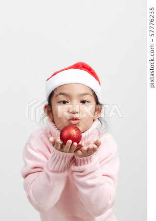 Girl holding a red christmas ball in sweater and Girl holding a red christmas ball in sweater and 57776238