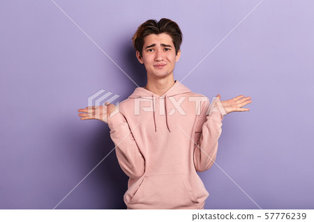 Closeup portrait of puzzled clueless young man shrugging his shoulders Closeup portrait of puzzled clueless young man shrugging his shoulders 57776239