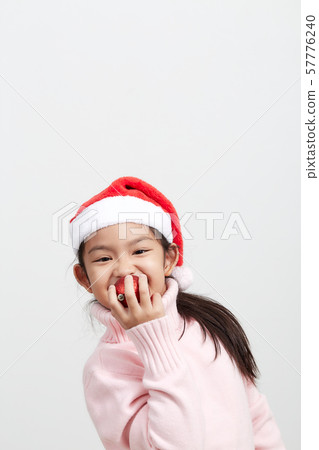 Girl holding a red christmas ball in sweater and Girl holding a red christmas ball in sweater and 57776240