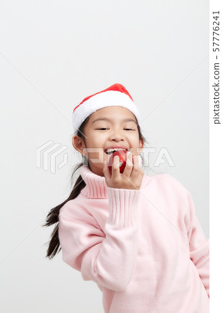 Girl holding a red christmas ball in sweater and Girl holding a red christmas ball in sweater and 57776241