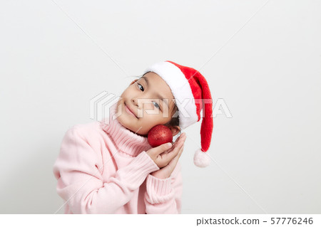 Girl holding a red christmas ball in sweater and Girl holding a red christmas ball in sweater and 57776246