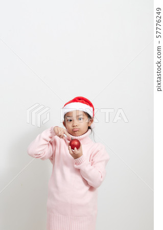 Girl holding a red christmas ball in sweater and Girl holding a red christmas ball in sweater and 57776249