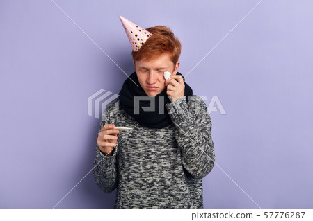 Unwell sick man has temperature, holding thermometer and cry. Unwell sick man has temperature, holding thermometer and cry. 57776287