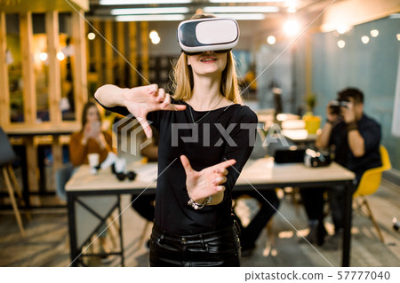 Woman in VR headset touching objects in virtual reality. Girl interacting with 3d visualization 57777040