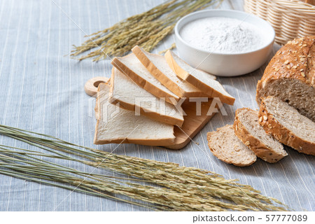 slide white bread ,whole wheat with whole grain bread and white blow of flour  57777089
