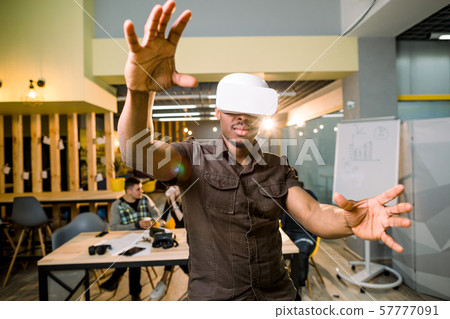 African-American man in casual wear using 3d virtual reality headset. Black gamer wearing goggles 57777091