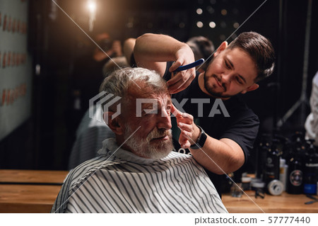young stylist going to shave beard with raizor 57777440