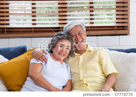 Asian couple senior embracing and sitting 57778770