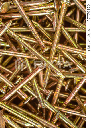 Texture of yellow nails on red background. 57779170