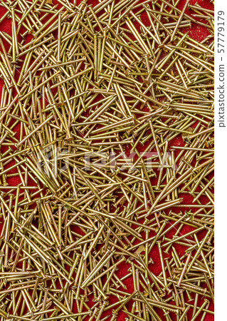 Texture of yellow nails on red background. 57779179
