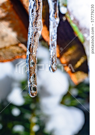 Frozen icicle on the edge of the roof of the house Frozen icicle on the edge of the roof of the house 57779230