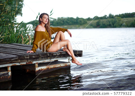 A beautiful Caucasian young girl sits in thought A beautiful Caucasian young girl sits in thought 57779322