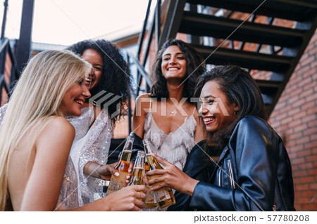 Happy friends celebrating outdoors at sunset.  57780208