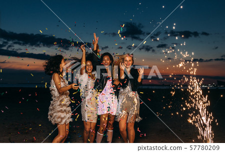 Happy friends celebrating outdoors at sunset.  57780209