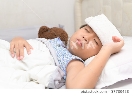 Sick child with high fever laying in bed. 57780428